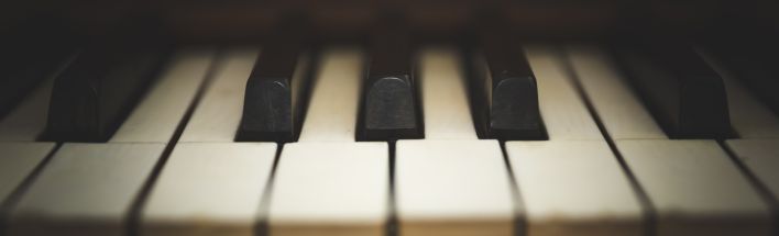 Grayscale Photo of Person Playing Piano